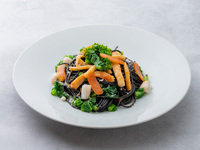 Spaghetti Noir with squid and scallops, served with spring vegetables.